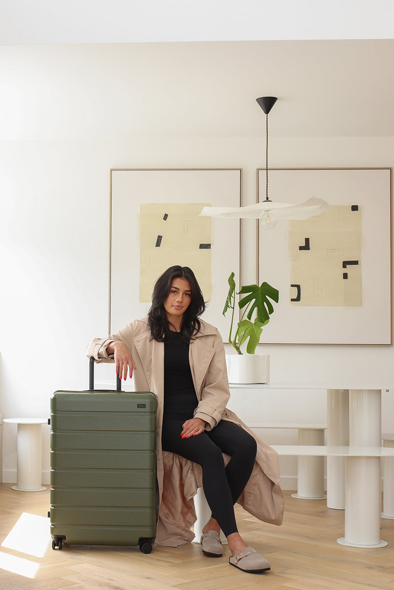 Model posing with Explorer Arlo Pro Large Suitcase Evergreen